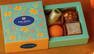 Royal Mithai Fusion Treats gift box with a floral turquoise lid and four sweets